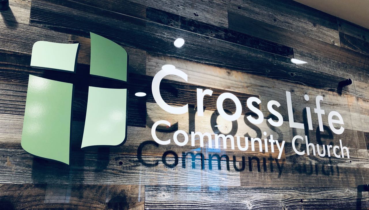 CrossLife Community Church lobby sign on reclaimed wood wall