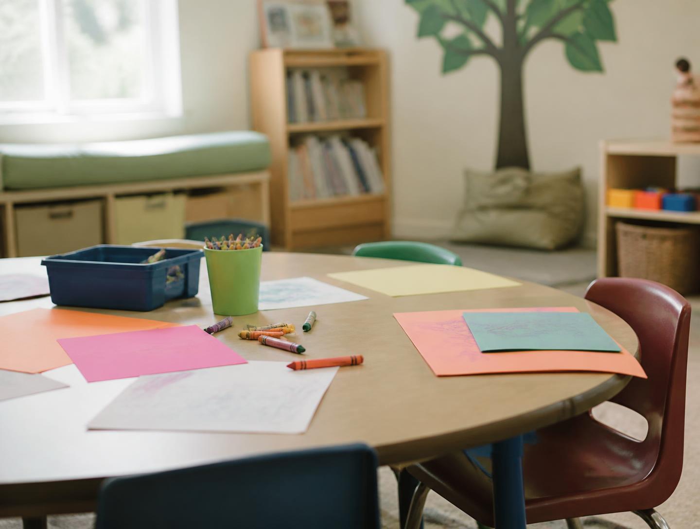 A CrossLife Kids classroom table with crayons and paper